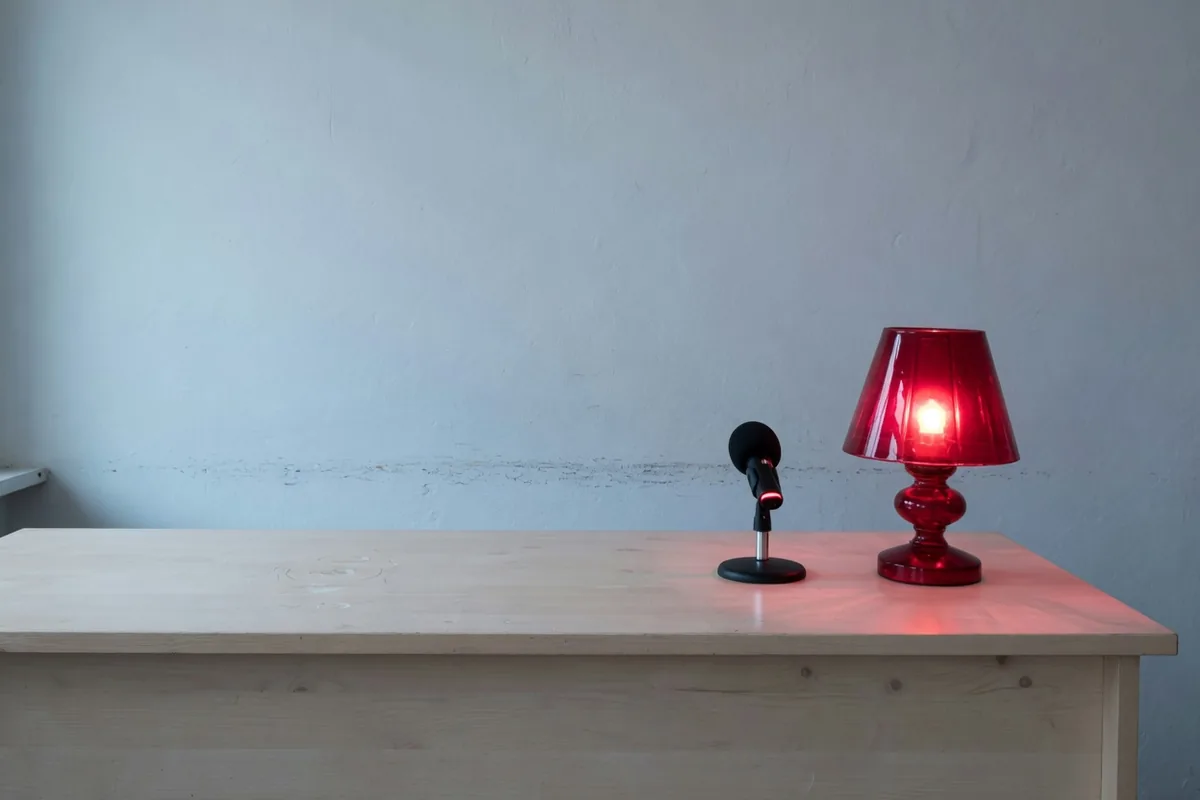 On doit savoir que c'est une machine Sur un comptoir nu, un micro de bureau à côté d'une lampe de verre rouge allumée.