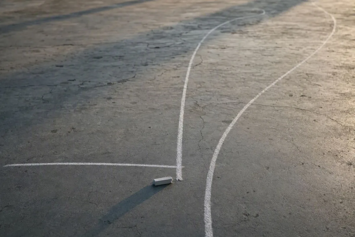 Trois traits de craie partent d'un même point sur un sol de béton : l'un reste plat, l'un file tout droit, l'un s'incurve vers le haut